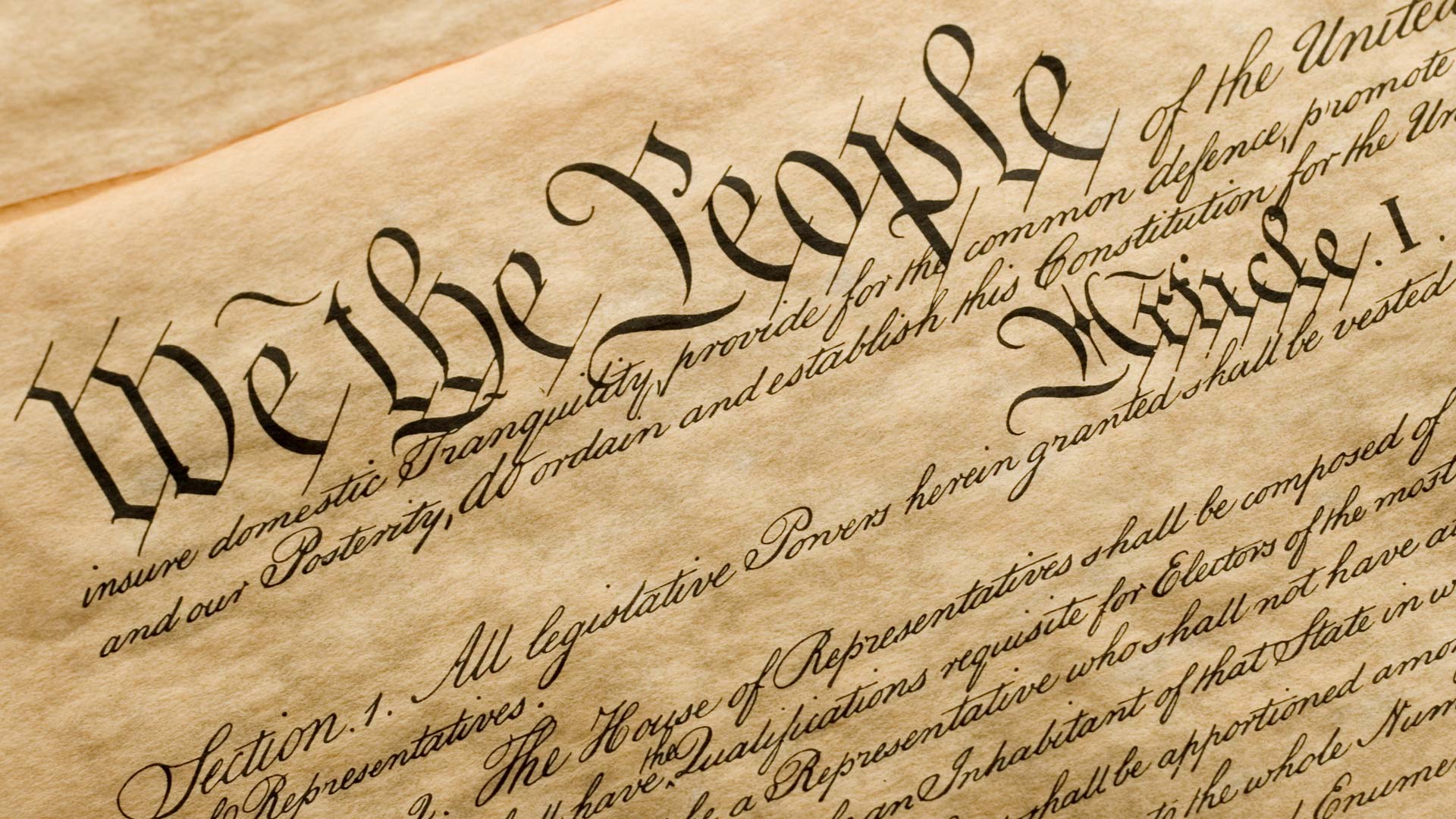 An image of the Constitution on parchments featuring the words "We the People"